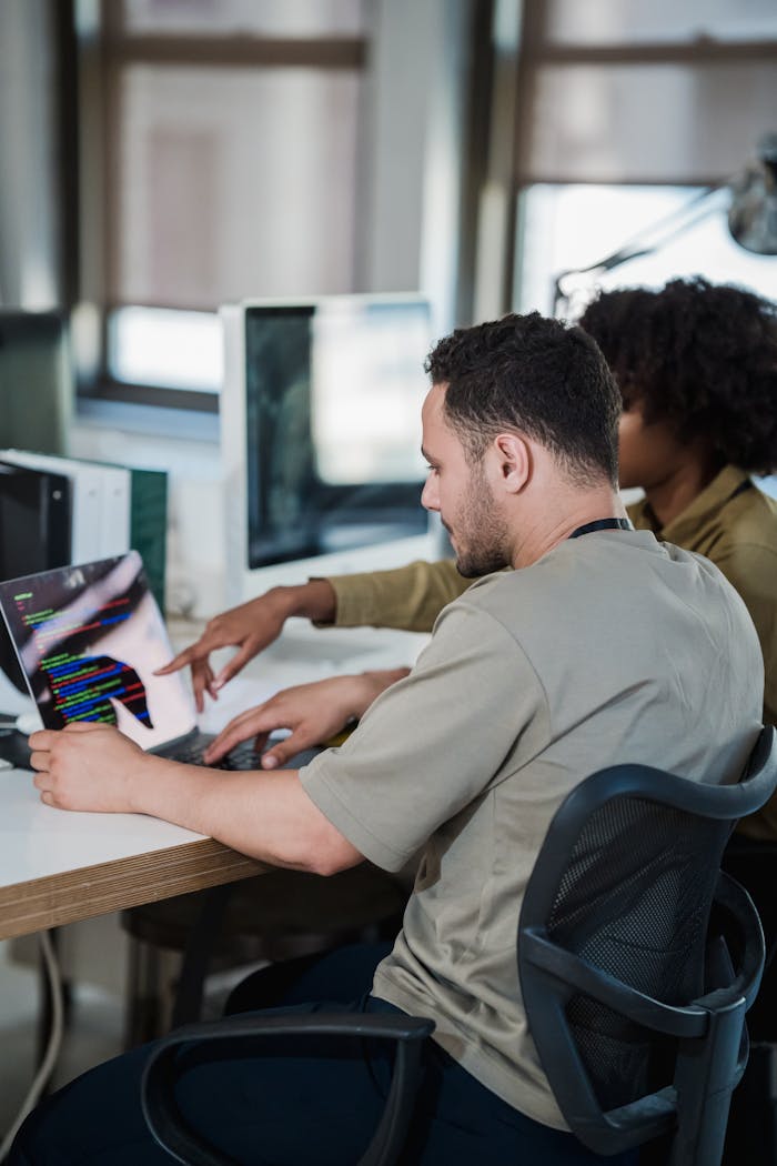 A diverse team collaborating on coding in a modern office environment.